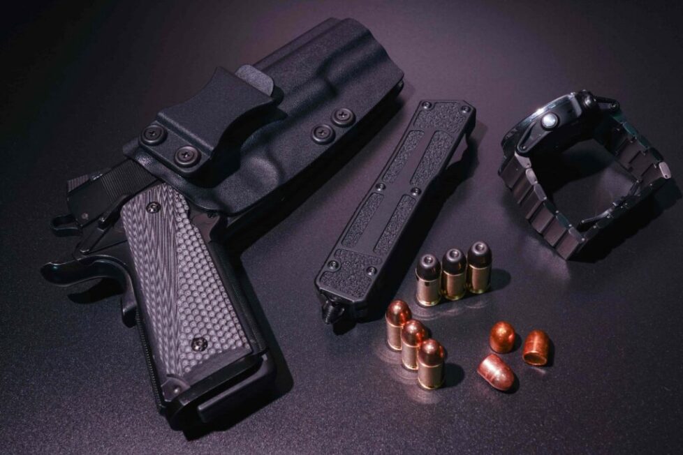 Carry kit for self-defense, m1911 pistol, folding knife, smartwatch and 45acp ammo.